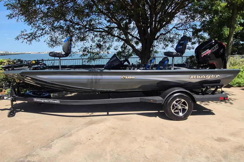 The Image of 2026 Ranger RT188 boat on trailer by lakeside, under tree shade. - 0
