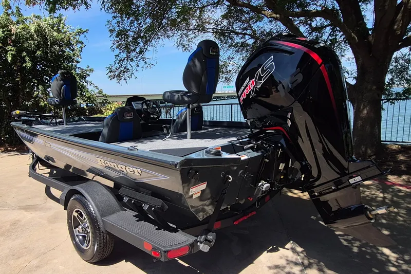 Slide: The Image of 2026 Ranger RT188 boat with powerful outboard motor, parked near a scenic waterfront. - 6