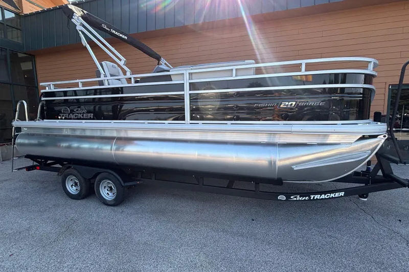 Slide: The Image of 2026 Sun Tracker Fishin' Barge 20 DLX pontoon boat on trailer, parked outdoors. - 3