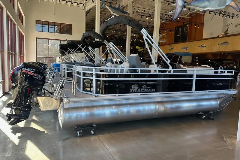 Slide: The Image of 2026 Sun Tracker Fishin' Barge 20 DLX pontoon boat displayed indoors. - 1
