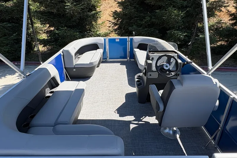 Slide: The Image of 2026 Sun Tracker Party Barge 16 DLX interior with spacious seating and steering console. - 19