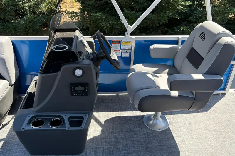 Slide: The Image of 2026 Sun Tracker Party Barge 16 DLX helm with comfortable captain's chair and control panel. - 13