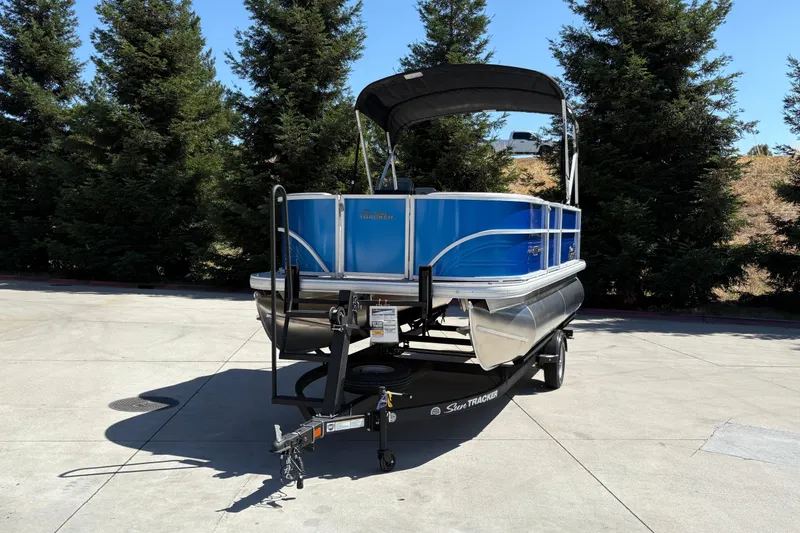 Slide: The Image of 2026 Sun Tracker Party Barge 16 DLX pontoon boat on trailer, parked outdoors. - 7