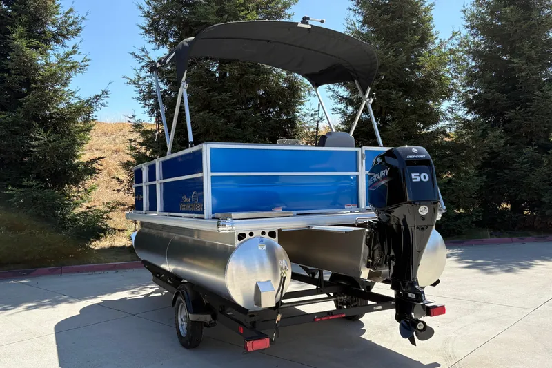 Slide: The Image of 2026 Sun Tracker Party Barge 16 DLX pontoon boat with Mercury 50 engine, parked outdoors. - 9