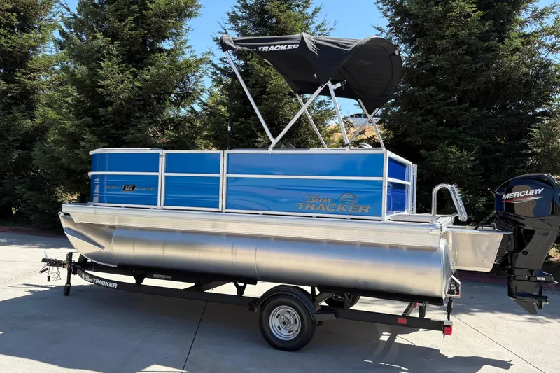 Slide: The Image of 2026 Sun Tracker Party Barge 16 DLX pontoon boat with Mercury engine on trailer. - 2