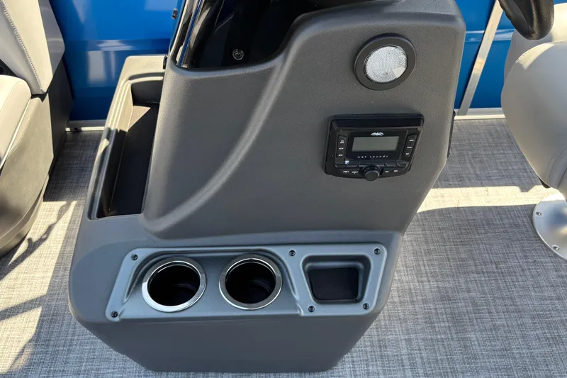 Slide: The Image of 2026 Sun Tracker Party Barge 16 DLX console with cup holders and audio controls. - 27