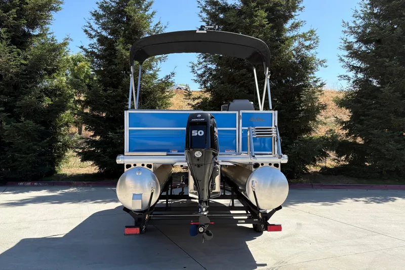 Slide: The Image of 2026 Sun Tracker Party Barge 16 DLX pontoon boat with outboard motor, parked outdoors. - 4