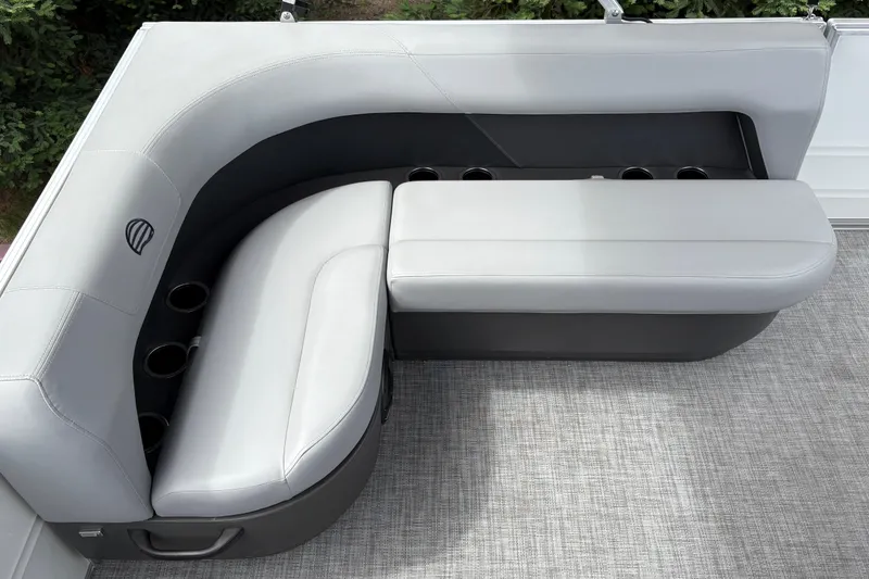 Slide: The Image of 2026 Sun Tracker Party Barge 16 DLX seating area with cup holders and gray upholstery. - 19