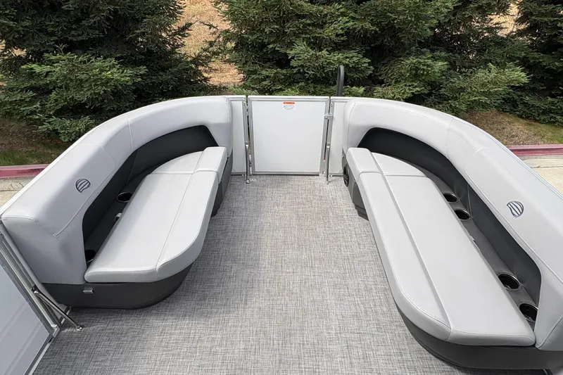 Slide: The Image of 2026 Sun Tracker Party Barge 16 DLX interior with gray seating and cup holders. - 17