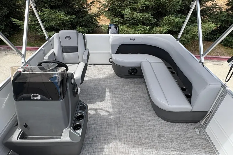 Slide: The Image of 2026 Sun Tracker Party Barge 16 DLX interior with gray seating and steering console. - 13