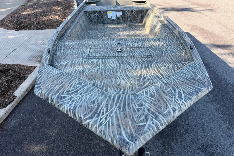 Slide: The Image of 2026 Tracker Grizzly 1648 Utility boat with camouflage pattern on a street. - 2