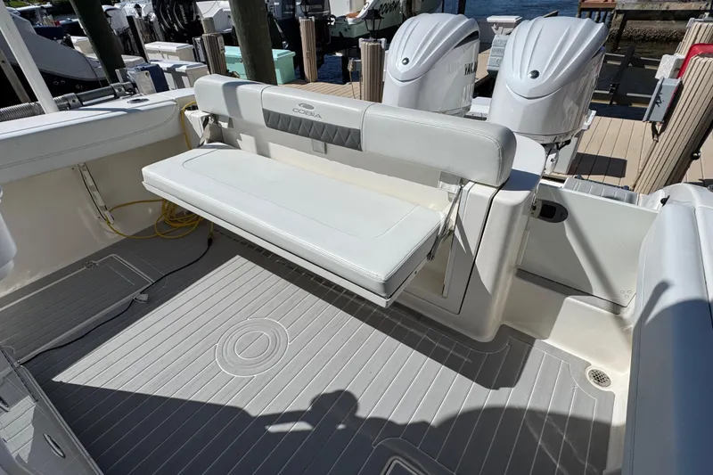 Slide: The Image of 2023 Cobia 280 Center Console boat with foldable seating and twin outboard engines. - 10