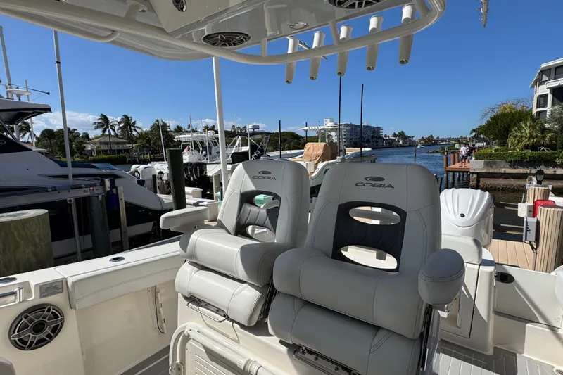 Slide: The Image of 2023 Cobia 280 Center Console boat interior with plush seating at marina. - 13