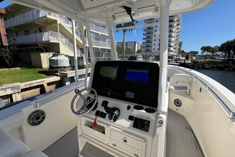 Slide: The Image of 2023 Cobia 280 Center Console boat interior with modern dashboard and steering wheel. - 14