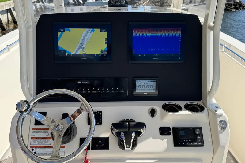 Slide: The Image of 2023 Cobia 280 Center Console helm with Garmin displays and steering wheel. - 15