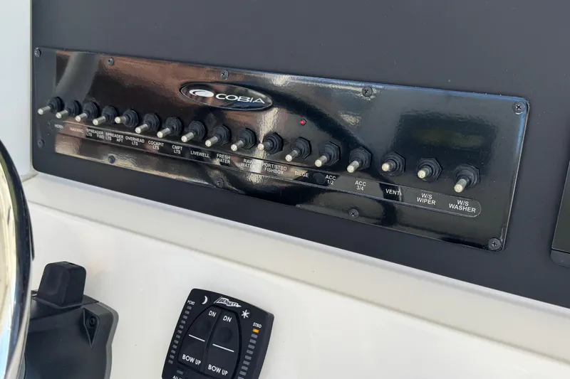 Slide: The Image of Control panel of 2023 Cobia 280 Center Console boat with labeled switches. - 16