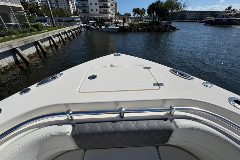 Slide: The Image of 2023 Cobia 280 Center Console boat docked in a marina with waterfront view. - 22