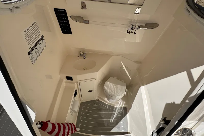 Slide: The Image of 2023 Cobia 280 Center Console boat interior with sink and toilet. - 27