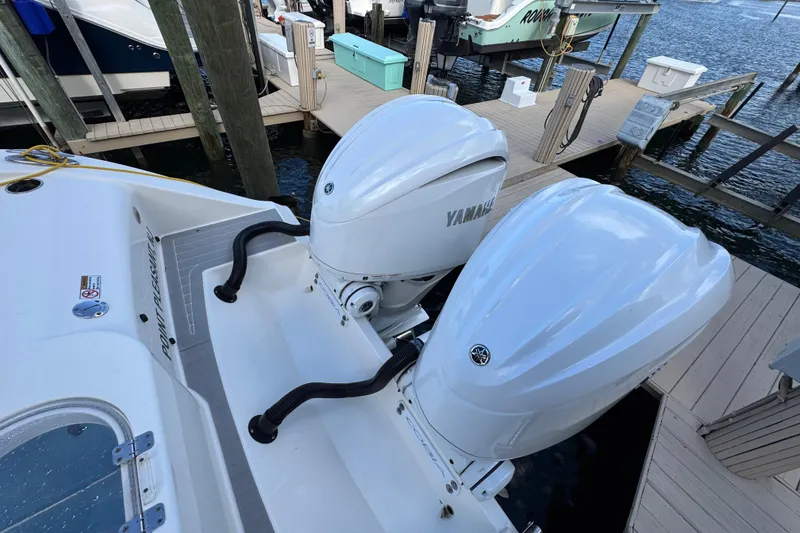 Slide: The Image of Twin Yamaha outboard engines on a 2023 Cobia 280 Center Console boat at dock. - 7