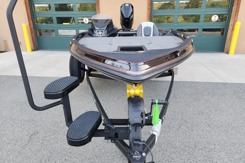 Slide: The Image of 2026 Ranger Z518 boat on trailer, parked outside garage with green doors. - 4