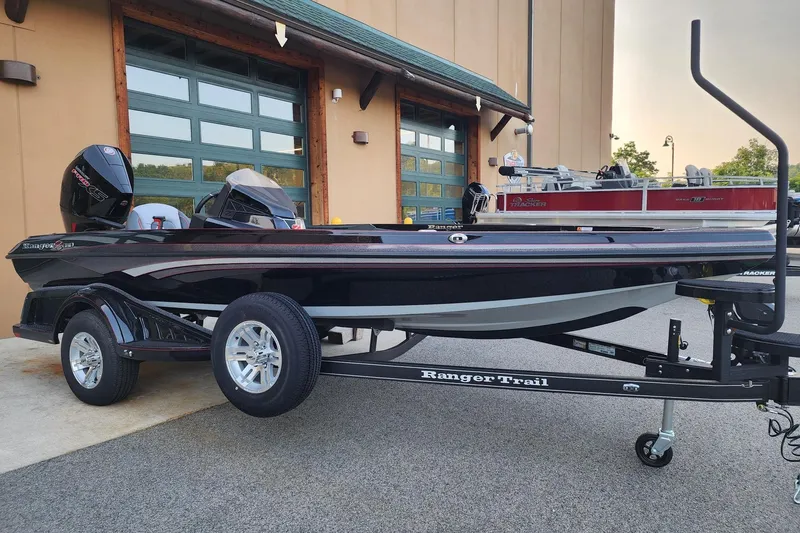 Slide: The Image of 2026 Ranger Z518 boat on trailer, parked outside a building with green doors. - 1