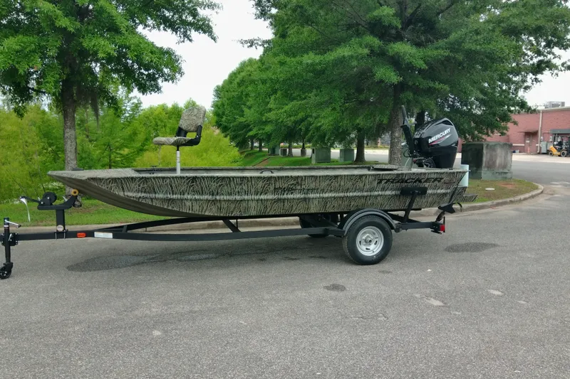 The Image of 2026 Tracker Grizzly 1654 T Sportsman boat on trailer, parked outdoors. - 0
