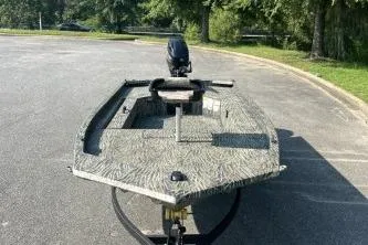Slide: The Image of 2026 Tracker Grizzly 1654 T Sportsman boat in a parking lot, featuring a camouflage design. - 40