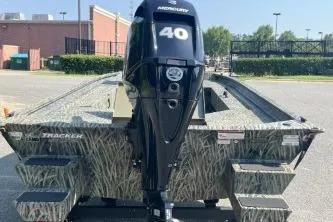 Slide: The Image of 2026 Tracker Grizzly 1654 T Sportsman boat with Mercury 40 engine, parked outdoors. - 41