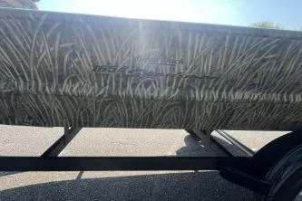 Slide: The Image of 2026 Tracker Grizzly 1654 T Sportsman boat with camouflage design on a trailer. - 44
