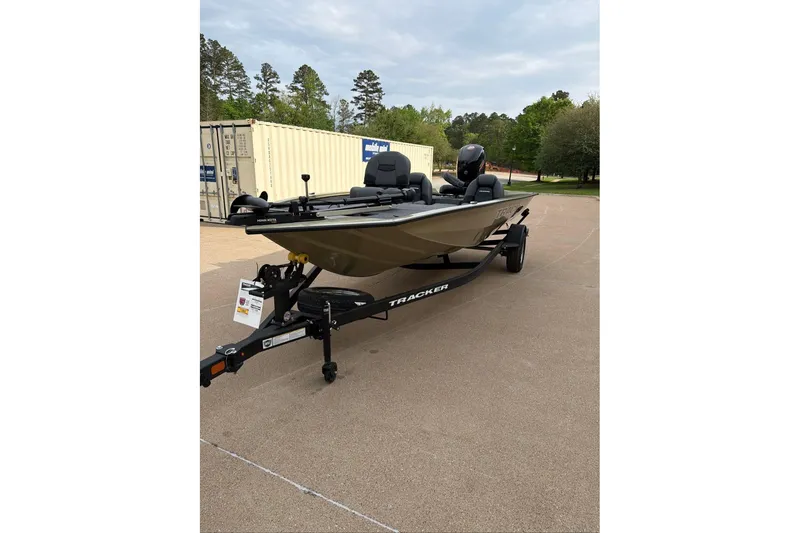 The Image of 2026 Tracker Pro Team 195 boat on trailer, parked outdoors near storage containers. - 0