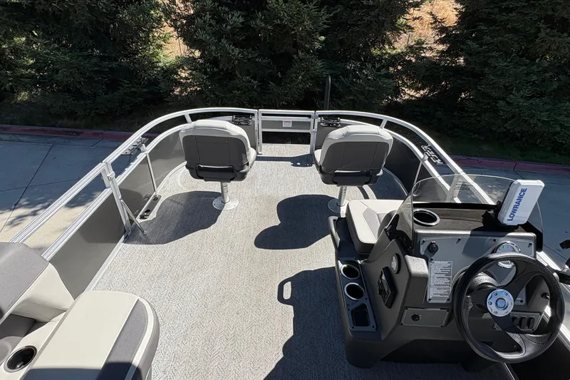 Slide: The Image of 2026 Sun Tracker Bass Buggy 16 XL Select pontoon boat interior with seating and steering console. - 12