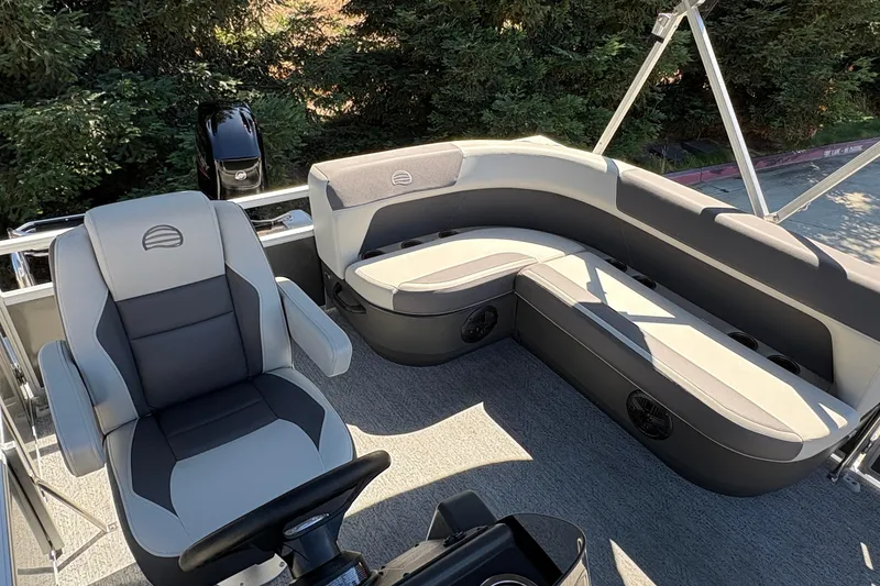 Slide: The Image of 2026 Sun Tracker Bass Buggy 16 XL Select pontoon boat interior with plush seating and steering console. - 7