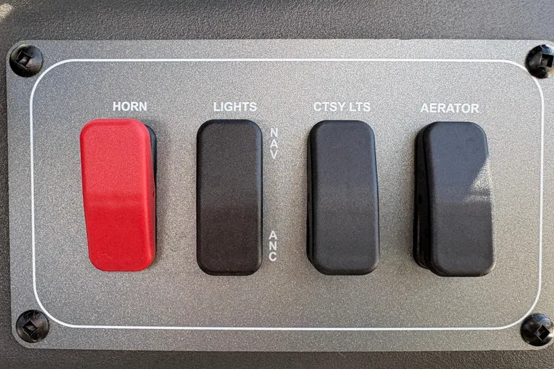 Slide: The Image of Control panel of 2026 Sun Tracker Bass Buggy 16 XL Select with horn, lights, courtesy lights, aerator switches. - 26