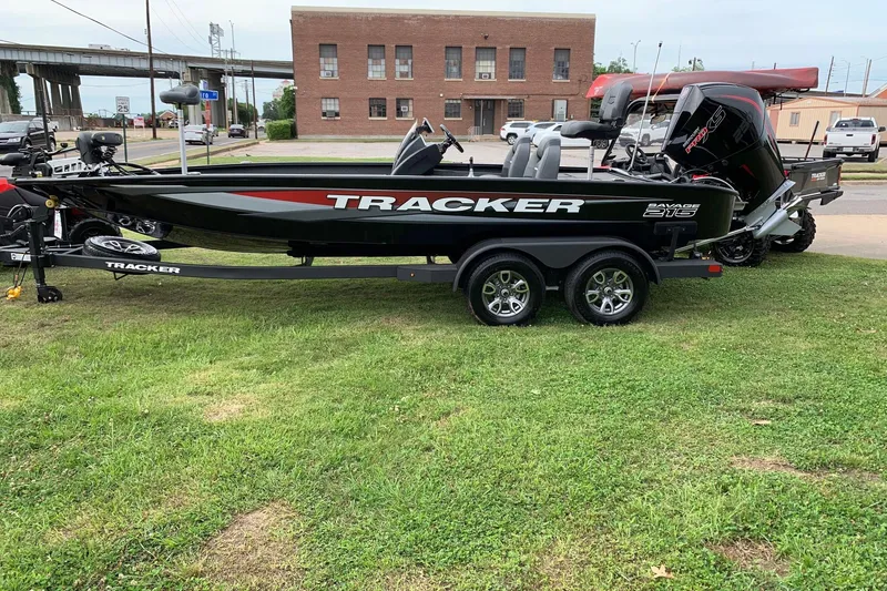 The Image of 2026 Tracker Savage 215 boat on trailer, parked on grass near urban area. - 0