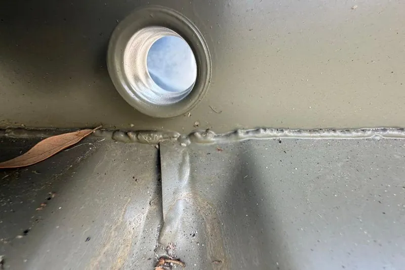 Slide: The Image of Close-up of Tracker Grizzly 10 Jon 2026 boat's interior weld and drain hole. - 32