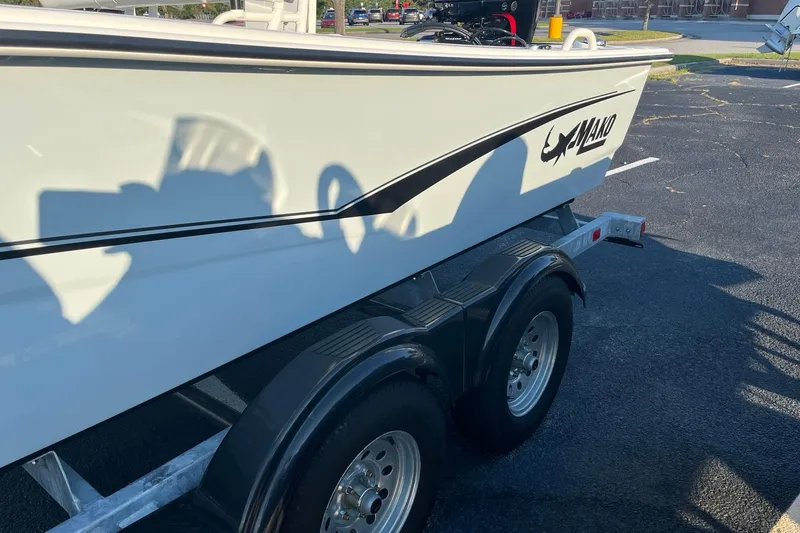 Slide: The Image of 2026 Mako Pro Skiff 19 CC boat on a trailer in a parking lot. - 3