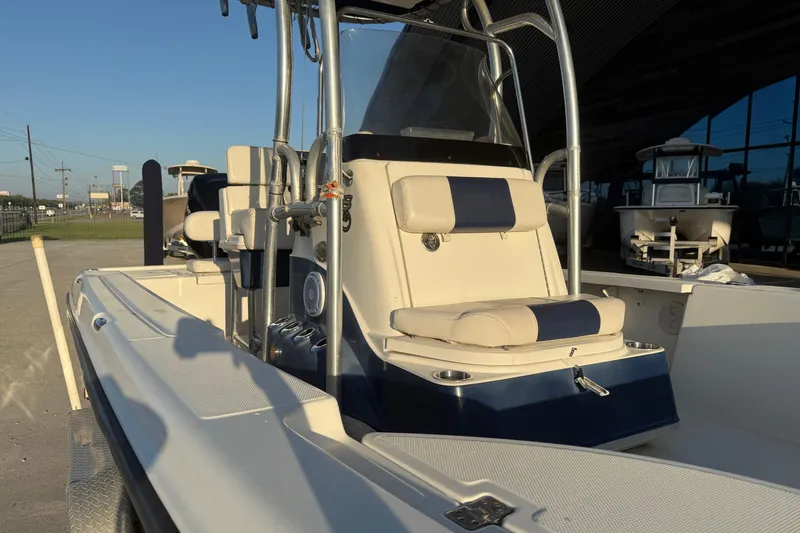 Slide: The Image of 2006 Triton 240 LTS boat interior with seating and console, parked outdoors. - 11