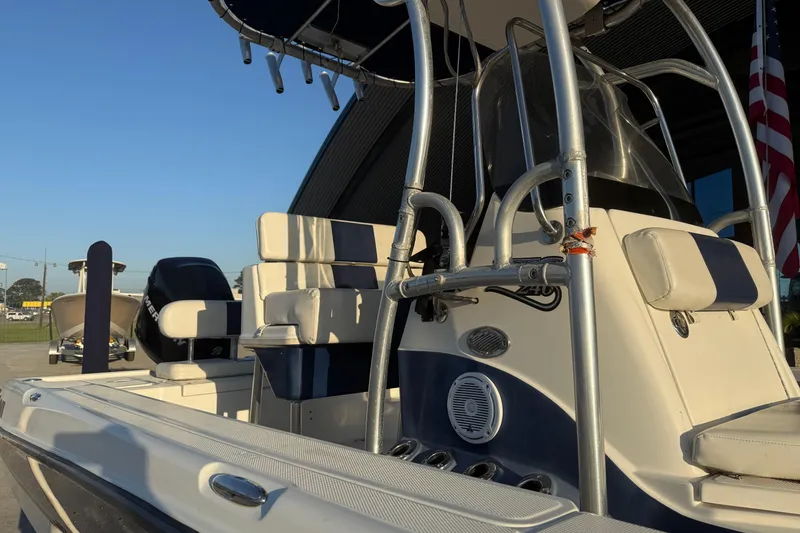 Slide: The Image of 2006 Triton 240 LTS boat with seating and console, parked outdoors under clear sky. - 12