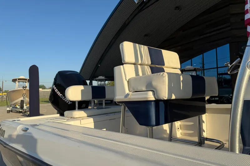 Slide: The Image of 2006 Triton 240 LTS boat with Mercury engine, featuring blue and white seating. - 13