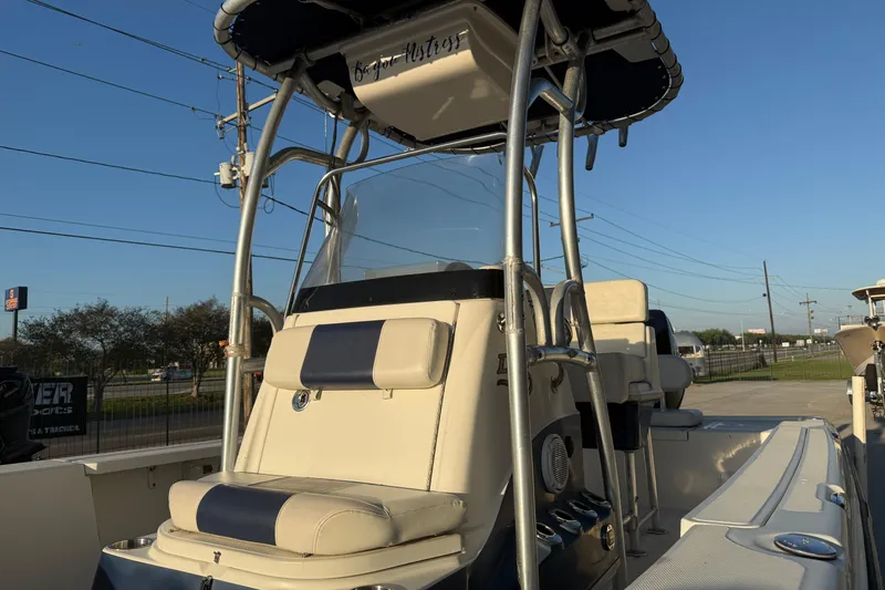 Slide: The Image of 2006 Triton 240 LTS boat with T-top and seating, parked outdoors under clear sky. - 15