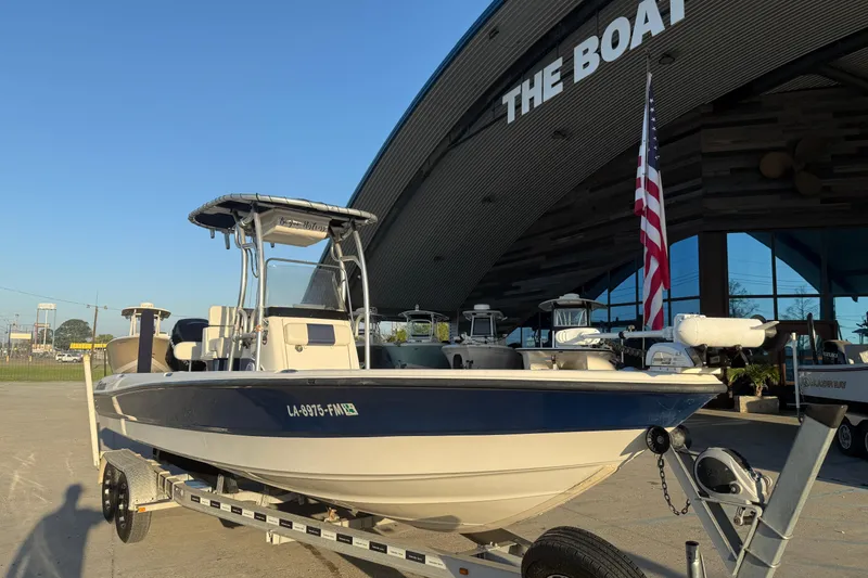 Slide: The Image of 2006 Triton 240 LTS boat on trailer outside dealership, American flag displayed. - 3