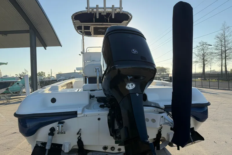 Slide: The Image of 2006 Triton 240 LTS boat with outboard motor, docked under a canopy. - 6