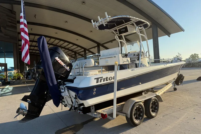 Slide: The Image of 2006 Triton 240 LTS boat with Mercury engine on trailer, parked outdoors. - 7