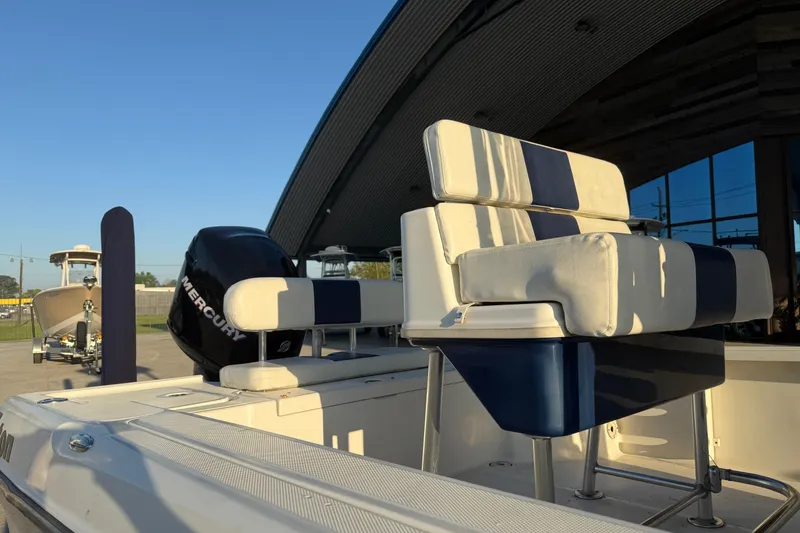 Slide: The Image of 2006 Triton 240 LTS boat with Mercury engine, featuring striped seating under a clear sky. - 9