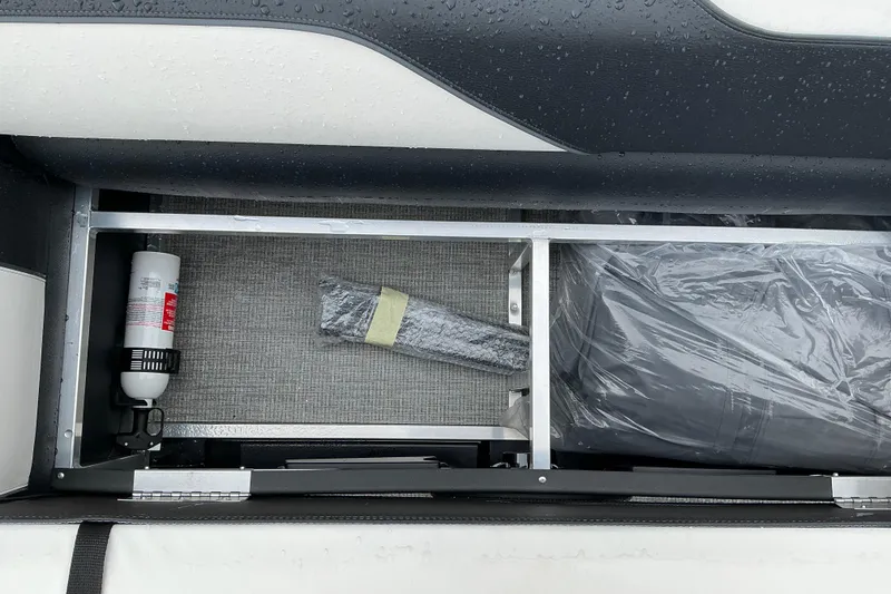 Slide: The Image of Storage compartment of 2026 Avalon Venture Quad Lounge boat, featuring safety equipment and accessories. - 10