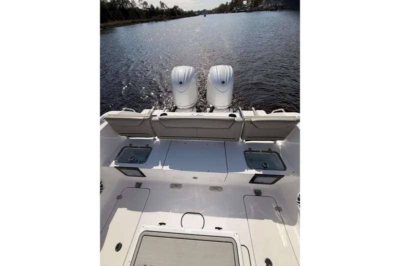 Slide: The Image of 2025 Sportsman Open 262 Center Console boat with twin engines on a calm waterway. - 17