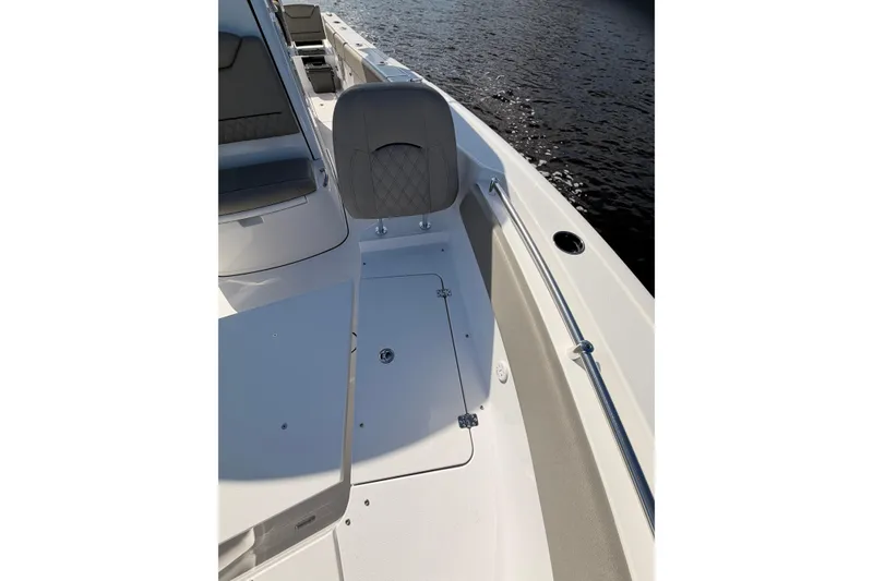 Slide: The Image of 2025 Sportsman Open 262 Center Console boat interior with seating and storage on calm water. - 10