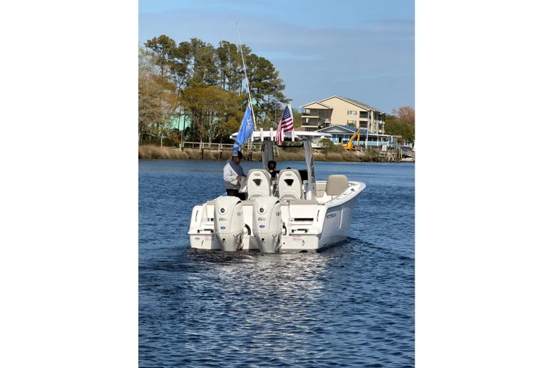 Slide: The Image of 2025 Sportsman Open 262 Center Console boat on water, flags flying, scenic background. - 3