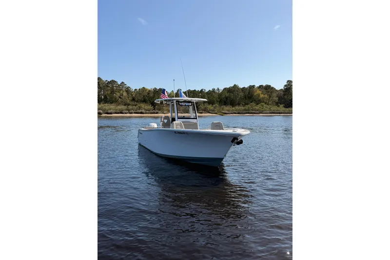 Slide: The Image of 2025 Sportsman Open 262 Center Console boat on calm water, with trees in the background. - 5