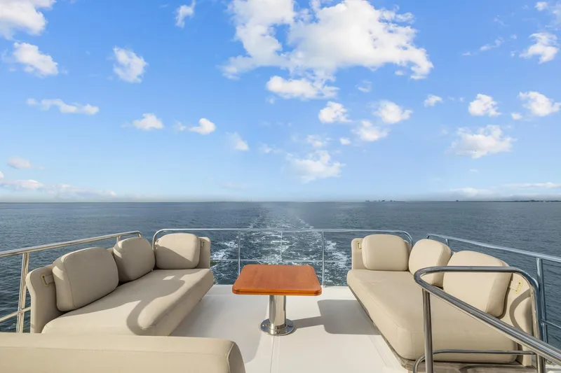 Slide: The Image of Luxurious 2019 Azimut 55 yacht deck with plush seating, ocean view, and clear blue sky. - 17
